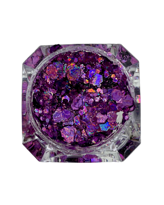 Top-down view of a clear faceted octagonal container filled purple glitter flakes, set against a plain white background.